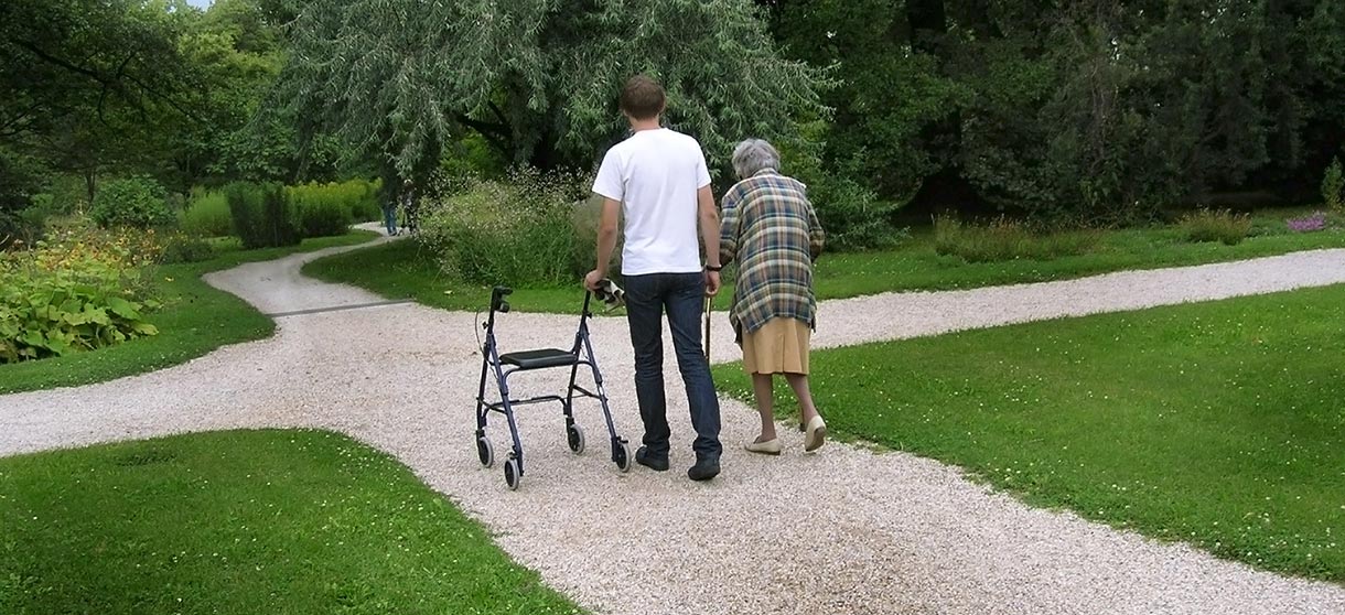 Ausbildungsbörse für Niedersachsen: Altenpfleger begleitet ältere Frau mit Rollator