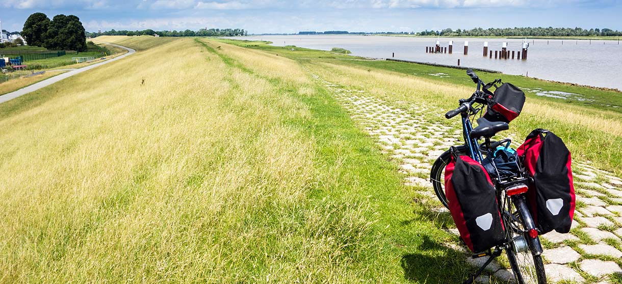 Fahrrad steht auf mit Gras bewachsener Düne